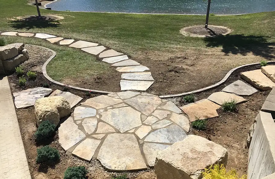 CanAm Professional Landscaping - landscaping project with flagstone paths and rock plant beds, lake side home - Girard, IL