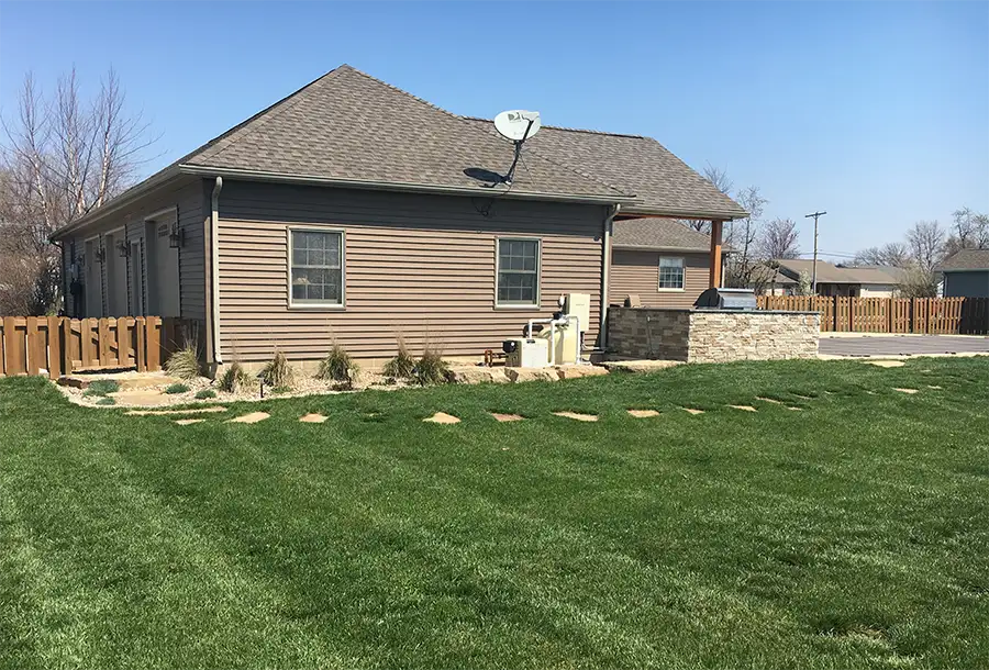 CanAm Professional Landscaping - landscaping project with flagstone pathway leading to back yard, fresh grass has been planted, after shot - Girard, IL