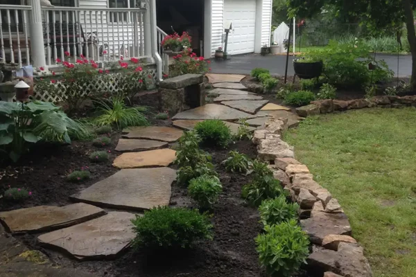 CanAm Professional Landscaping - front of house rock, flagstone walkway with plant beds and fresh mulch - Girard, IL